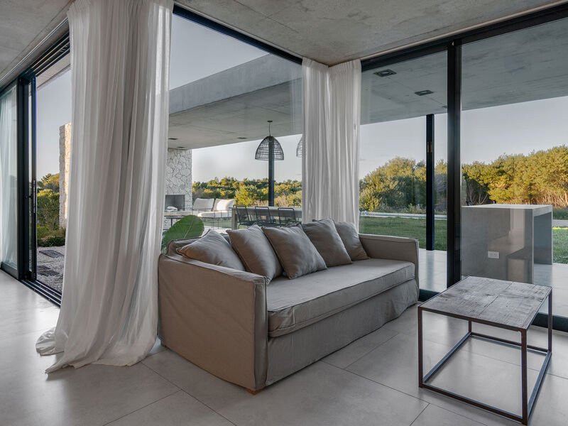Living con aberturas PVC corredizas piso a techo y vista al jardin